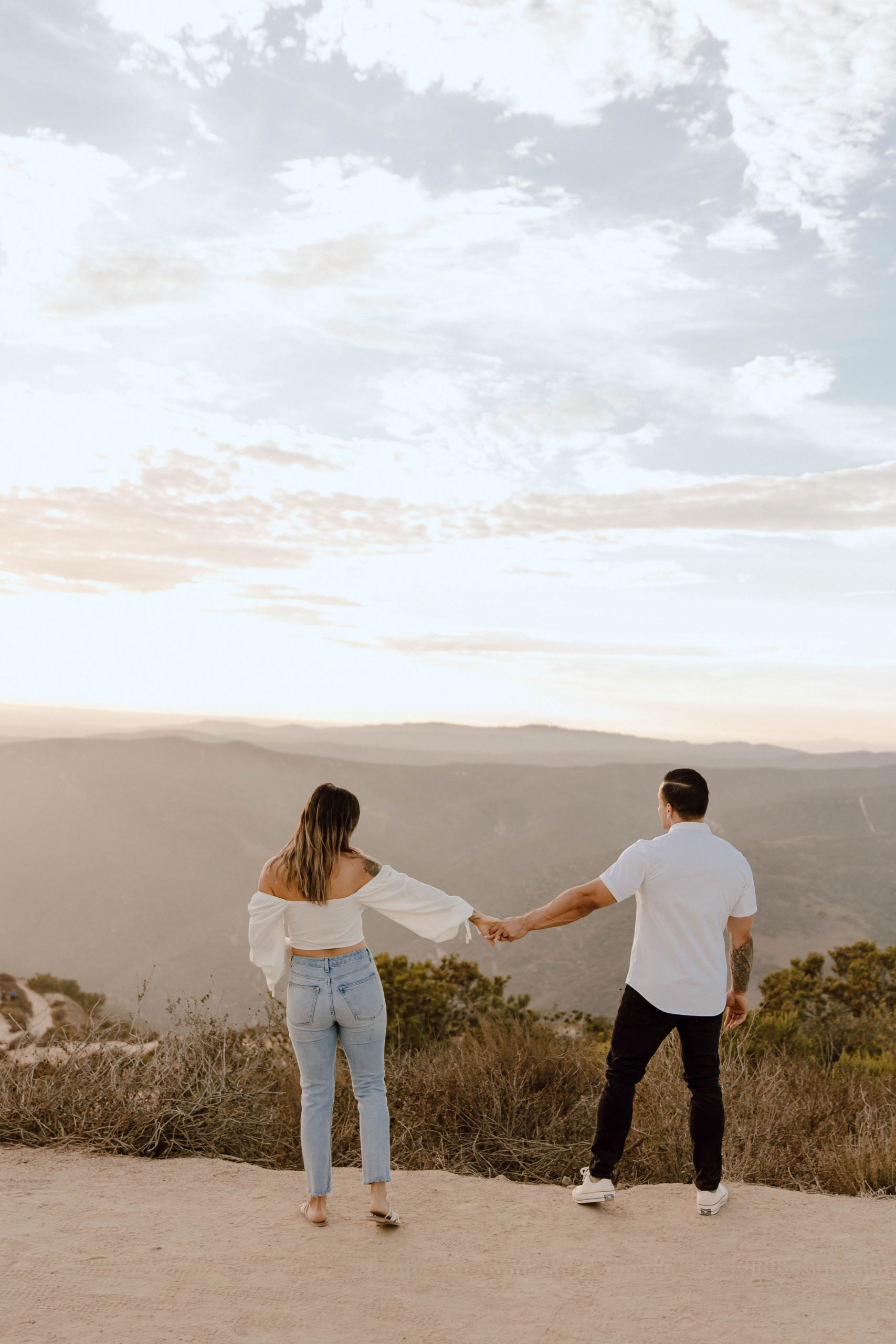 couple is holding hands and looking out at the view