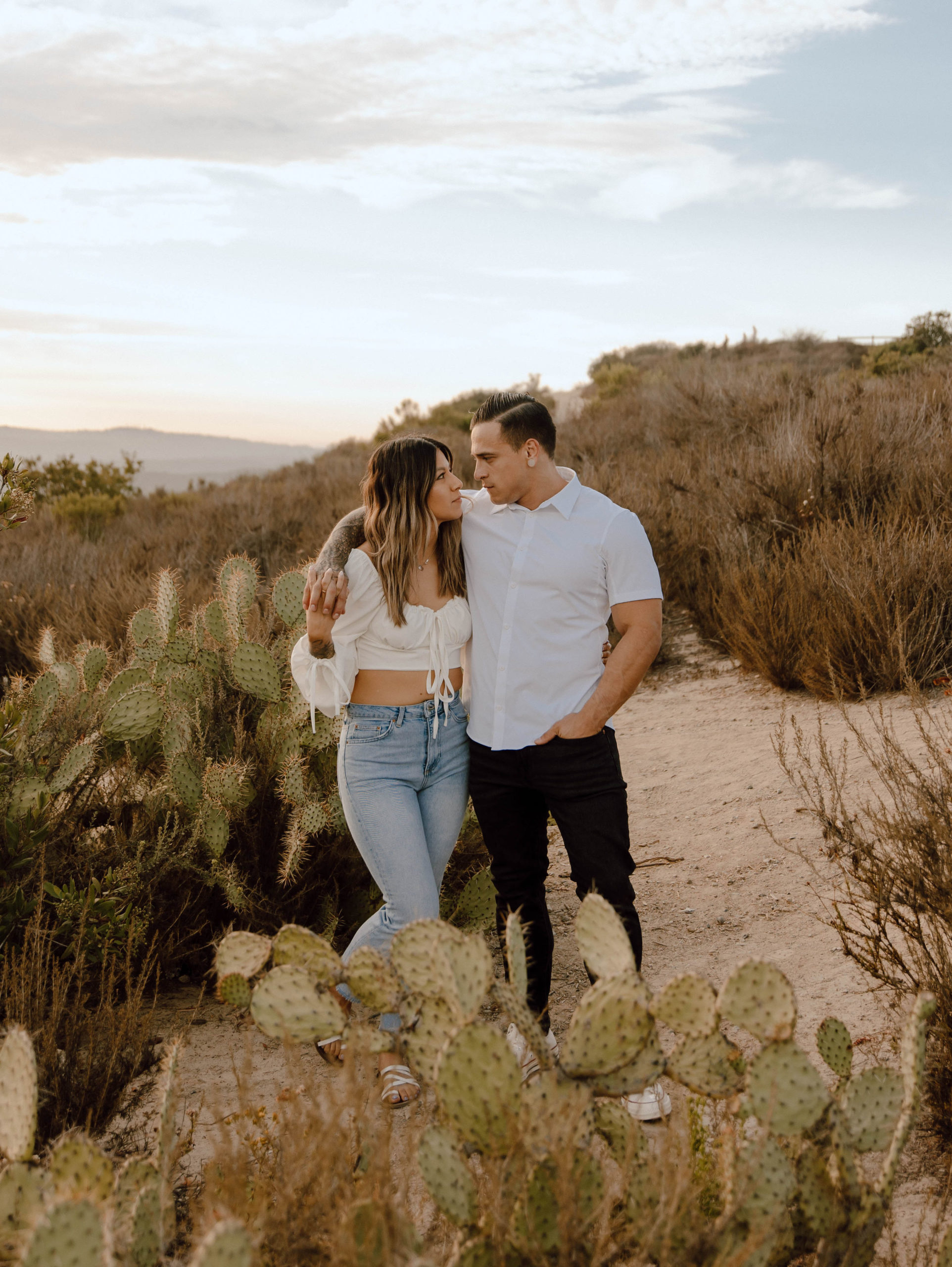 couple looking at each other next to the cacti